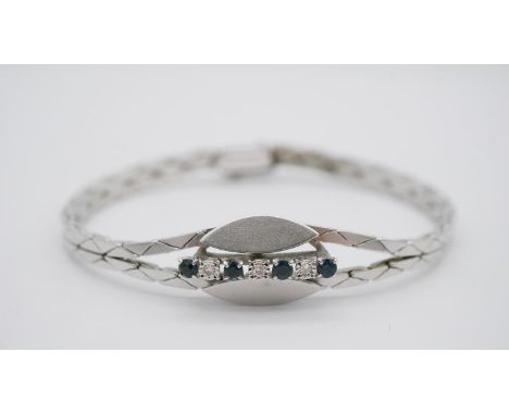 A vintage 14 carat white gold, sapphire and diamond abstract design articulated bracelet. Set with four round mixed cut sapph