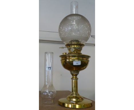 A brass table oil lamp with spare chimney