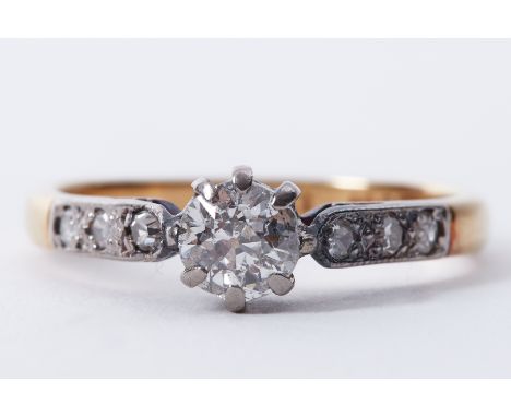 An 18ct yellow gold &amp; platinum ring set with a round cut diamond, approx. 0.50 carats with three small round cut diamonds