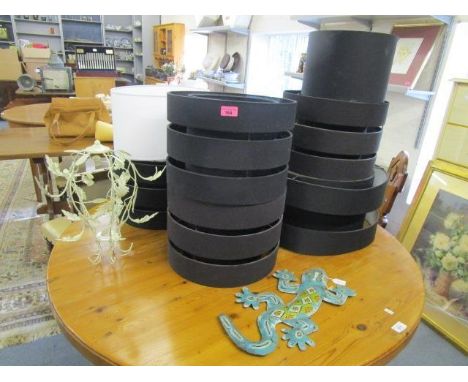 Seven lamp shades in black and white, a cream painted metal lamp and a similar wall mounted lizard 