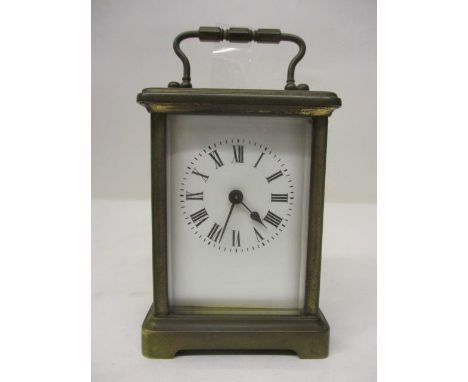 An early 20th century French brass carriage clock having bevelled glass panels and a white enamel dial with Roman numerals, 5