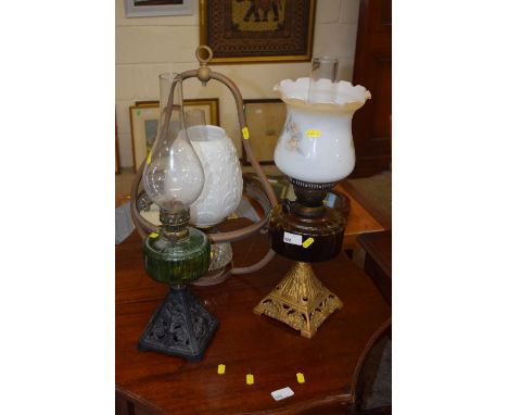 Two cast base oil lamps and a further hanging oil lamp (3)