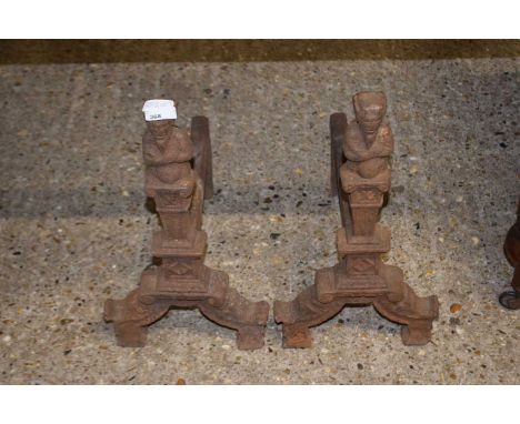 A pair of cast iron fire dogs or grate supports with figural decoration