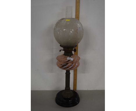 An oil lamp with frosted glass shade, swirled glass font and a column base
