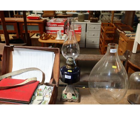 An oil lamp with cast iron base and blue glass reservoir 