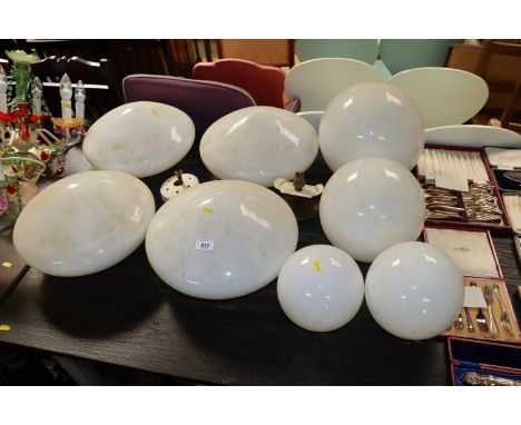 A collection of white globe and other opaque light shades