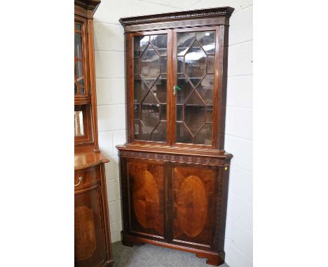 A Reproduction Mahogany Part-Glazed Standing Corner Cupboard, with dentil cornice and blind fret work decoration, on bracket 