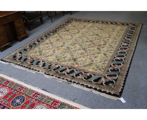 An Oriental Carpet, the pale lemon diamond lattice field of floral design enclosed by meandering vine borders, 293cm by 239cm