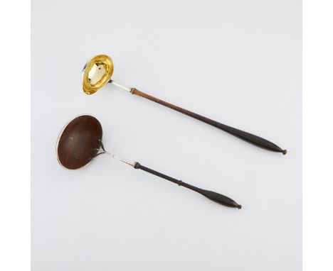 Group of two silver ladles. One with a wooden handle and a silver piece in the form of a taloned leg connected to a coconut s