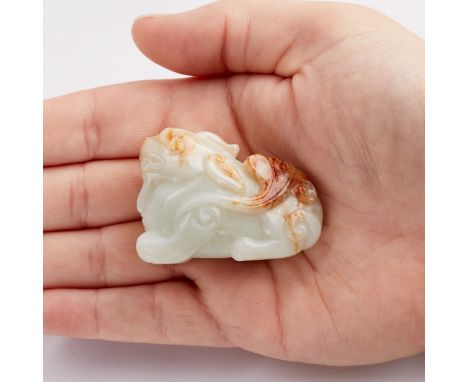 Modern Chinese carved jade in the form of a qilin with lovely russet inclusions.Height: 1 1/2 in x width: 2 in x depth: 1 in.