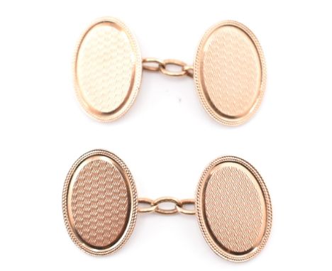 A pair of hallmarked 9ct rose gold cufflinks. The 9ct rose gold chain style cufflinks having oval heads with engine turn repe