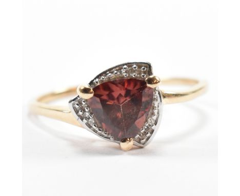 A hallmarked 9ct gold zircon and diamond cluster ring. The 9ct yellow gold ring set with a central trillion cut zircon surrou