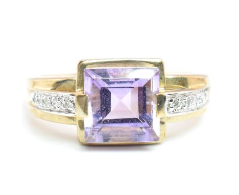 A hallmarked 9ct gold amethyst and diamond ring. The ring set with a central step-cut amethyst to diamond set shoulders. Weig
