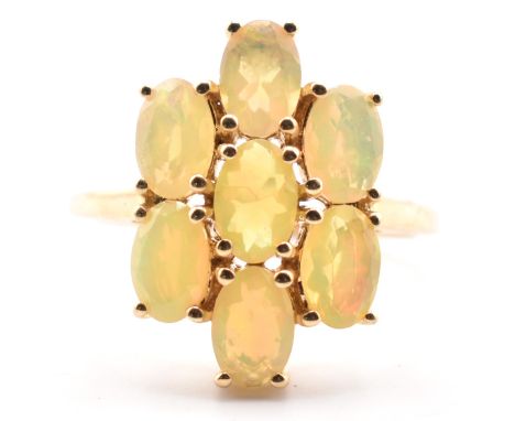 A hallmarked 9ct gold Ethiopian opal cluster ring. The 9ct yellow gold ring set with seven oval cut Ethiopian opals to polish