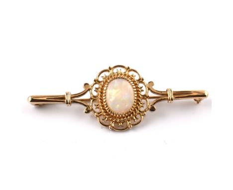A hallmarked 9ct gold and opal brooch pin. The 9ct yellow gold brooch pin having a central oval opal cabochon set in a decora