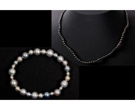 two jewels : a bracelet with white and light grey pearls and a necklace with small dark pearls with a lock in yellow gold (18
