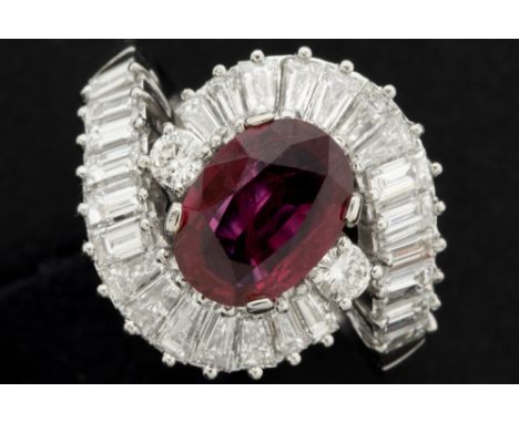 classic probably seventies' ring in platinum with a 1,72 carat oval Thai ruby, surrounded by ca 1,60 carat of very high quali