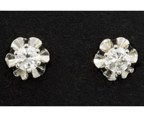 pair of earrings in white gold (18 carat) each with a small high quality brilliant cut diamondPaar oorbellen, zgn dormeuses, 