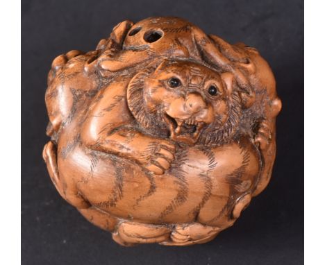 An early 20th Century Japanese hand carved netsuke in the form of a ball, Carved profusely depicting fighting tigers. Signed,