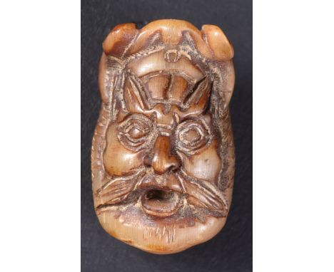 A 19th Century Chinese hand carved rhino horn netsuke / bead. Depicts a deity / demon face with hand carved features and poli