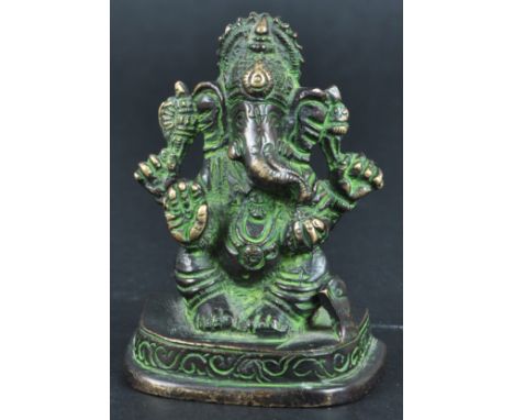 A 20th Century Indian bronze figurine in the form of Ganesh. Green verdigris finish with the elephant headed deity modelled s