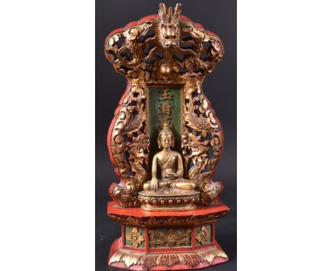 A 19th Century Chinese bronze figurine depicting Buddha modelled on lous pedestal base set within a large ornate gilt &amp; r