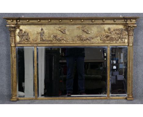 A Regency gilt overmantel mirror with ball decorated architectural cornice above frieze with Classical figures in relief and 