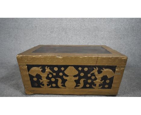 An Eastern teak trunk with twin metal carrying handles and embossed gilt metal decoration. H.30 W.60 D.31 