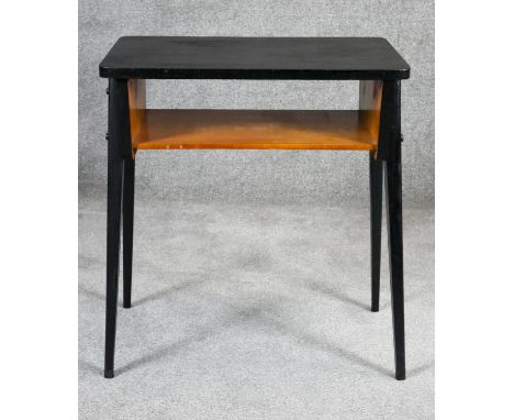 A retro vintage ebonised magazine table on splay supports. H.69 W.62 D.39cm 