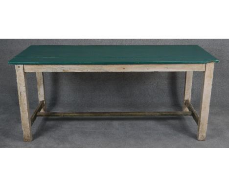 A vintage distressed painted planked top kitchen dining table on square stretchered supports. H.78 L.180 D.75cm 