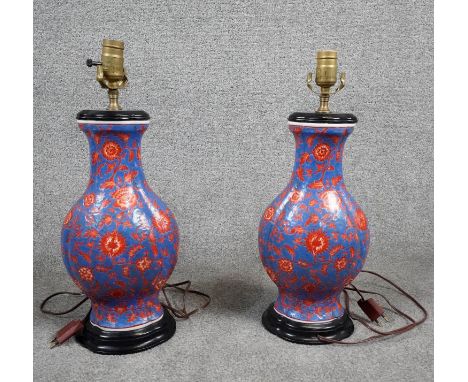 A pair of vintage hand painted ceramic Chinese vase design table lamps, stylised red flowers on a blue ground with painted bl