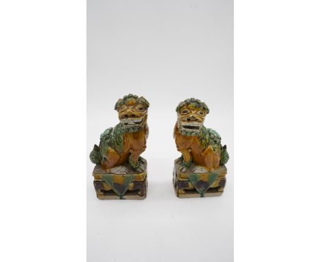 A pair of Sancai Kangxi style late Qing ceramic Foo dogs with green and yellow glaze. Unmarked. H.19 W.9 