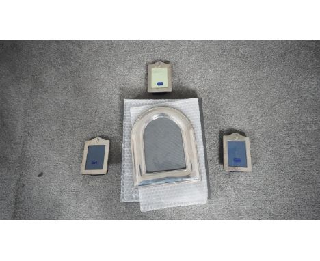 A collection of four sterling silver picture frames. Three F&amp;W small rectangular silver photo frames with peter rabbit mo