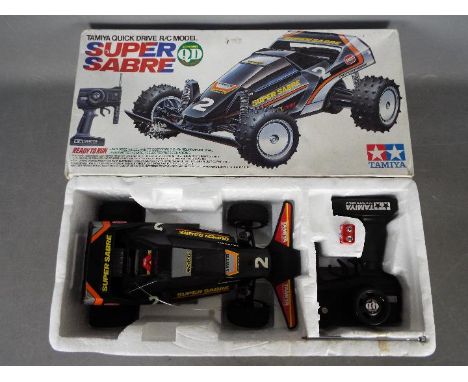 Tamiya - An assembled and boxed vintage 1988 Tamiya #46002 1:14 scale R/C Quick Drive Super Sabre buggy. The assembled model 