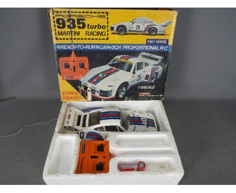 Sanwa - An assembled and boxed Sanwa SRC2500M 1:12 scale Ready to Run Porsche 935 Turbo Martini Racing car  The model shows s