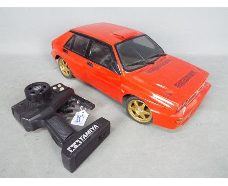 Tamiya - An assembled and unboxed Tamiya RC 'Quick Drive' 1:10 scale Lancia Delta. The model shows signs of use, with body sh