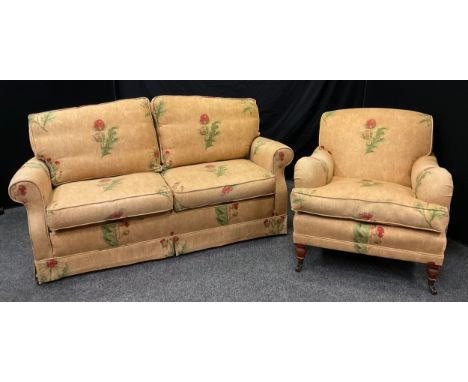 A contemporary serpentine-back three-seat sofa, and a conforming armchair, down-filled upholstery, turned mahogany legs, cera