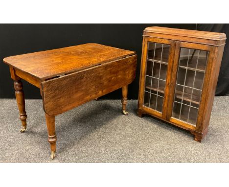 A Victorian oak kitchen table, with single drop-leaf, rounded rectangular top, turned legs, ceramic casters, 75cm tall x 110.