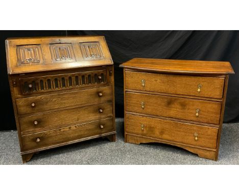 A mid 20th century oak bureau, three-panel fall door to top with carved linen-fold decoration, above four drawers, bracket fe
