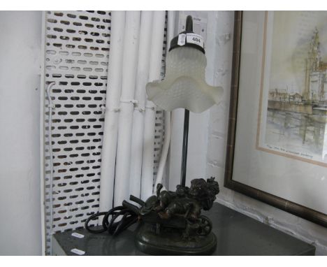 A cast figure lamp with frosted glass shade 