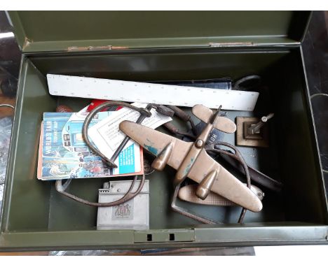 A tin and contents including an old hand cuff, a lighter, an Art Deco style brass bomber on stand, rule, scale etc. 