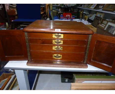 A large Mahogany case canteen (incomplete) of cutlery with double doors and pull out drawers having brass handles to include 
