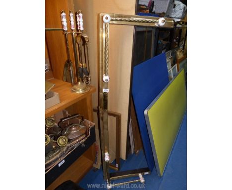 A fender and matching companion set, brass coloured with ceramic detail.