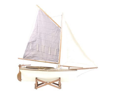 A wooden scale model single-masted sailing boat, on stand, 73cm x 71 cm