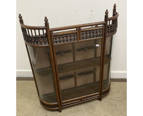 A circa 1900 oak framed and glazed wall cabinet in the manner of Liberty of London with bobbin-turned and galleried decoratio