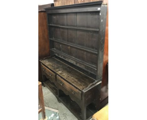 An oak dresser in the 18th Century style, the three tier boarded plate rack over two drawers, on square supports united by a 