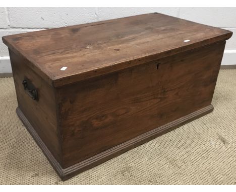 A 19th Century elm trunk with wrought iron carrying handles on a shallow reeded plinth base, 79.5 cm wide x 46 cm deep x 38.5
