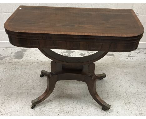 An early 19th Century rosewood and satinwood strung fold-over card table, the cross-banded top opening to reveal a green baiz