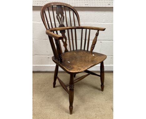 A 19th Century Thames Valley ash and elm stick back elbow chair with fretwork carved back splat, the arms on turned and ringe