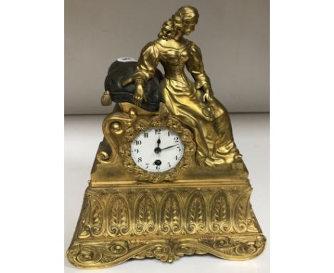 A 19th Century French gilt bronze cased figural mantel clock decorated with recumbent lady leaning on a cushion, the movement